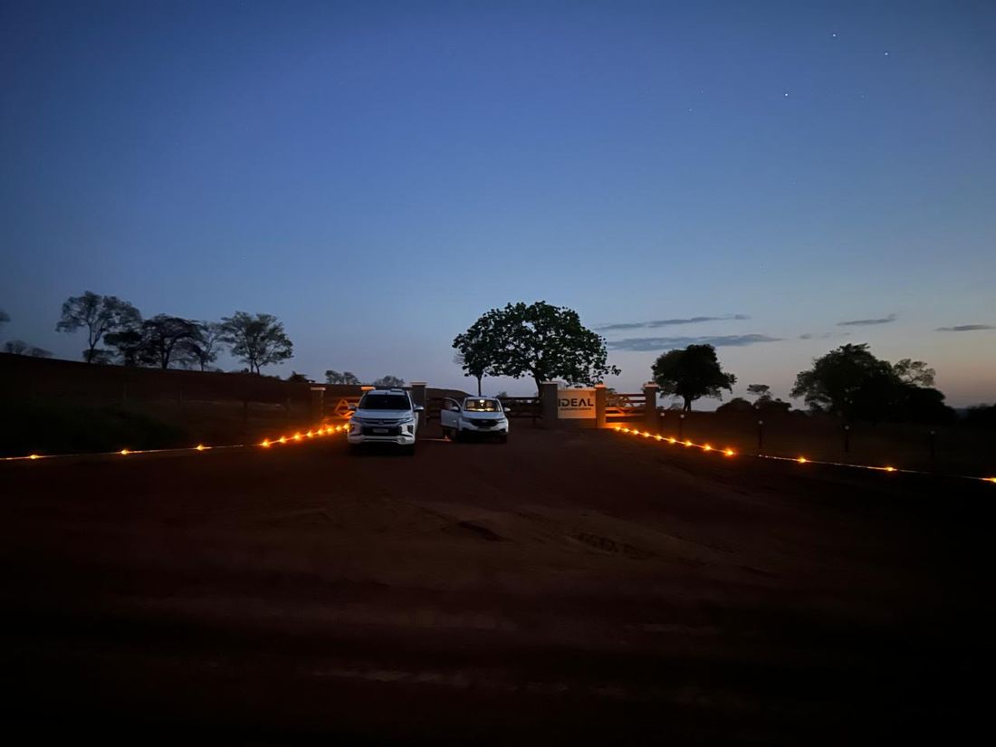 Entrada de fazenda em estrada de terra marcada por tachas de Led's